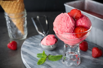 Photo of Delicious strawberry ice cream in dessert bowl served on grey table