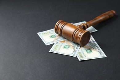 Photo of Law gavel with dollars on grey table, space for text