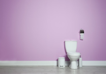 Photo of New ceramic toilet bowl in modern bathroom with space for text