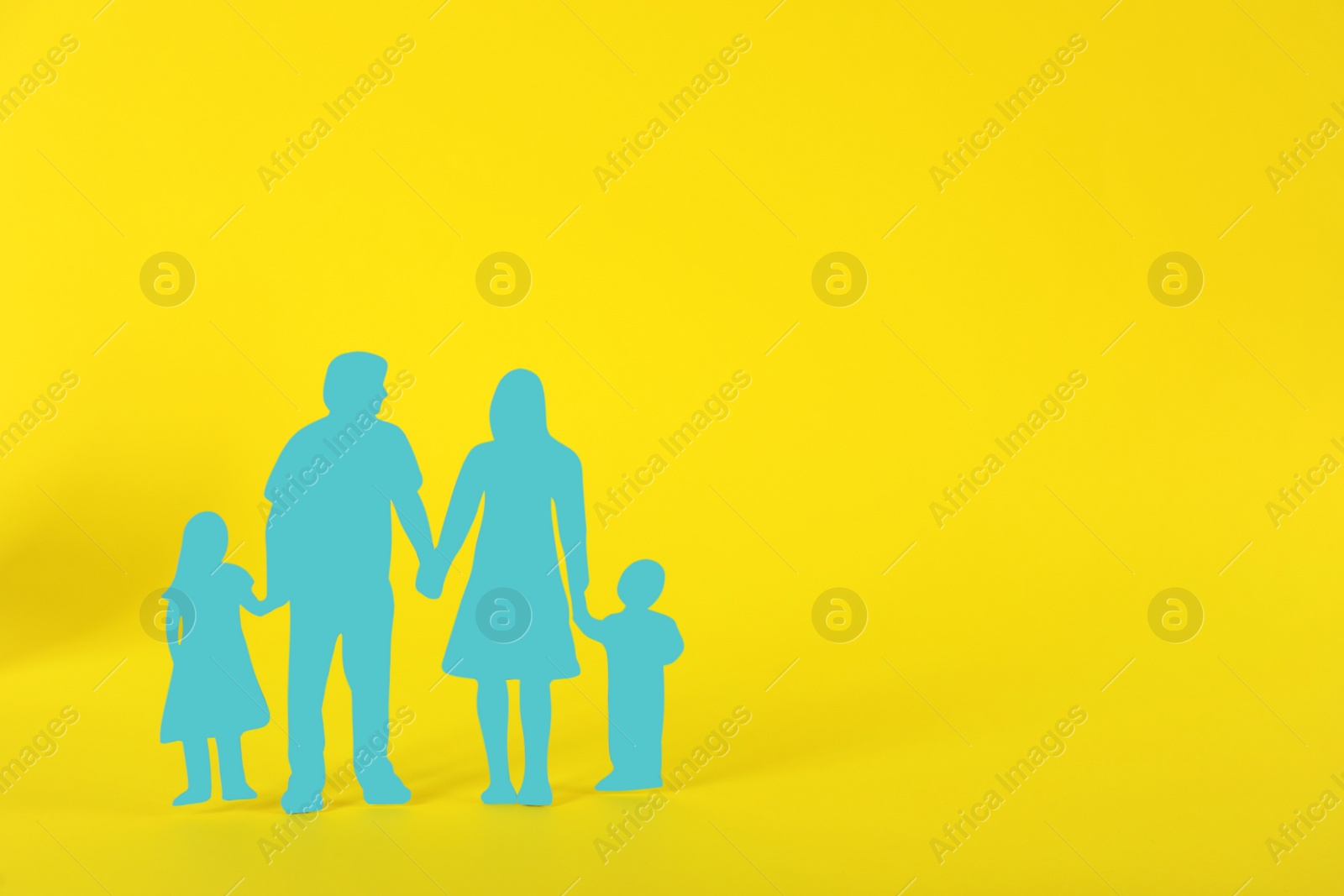 Photo of Paper family figure on yellow background, space for text. Child adoption concept