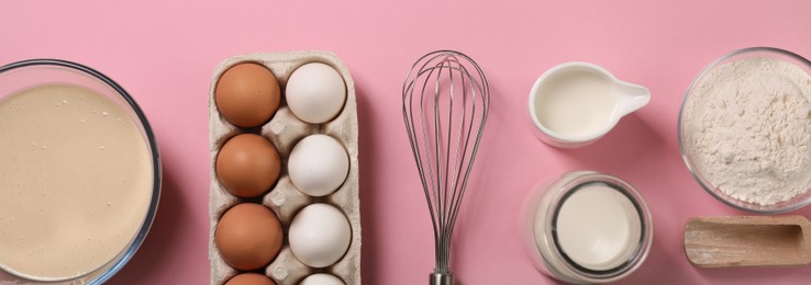 Metal whisk and and dough ingredients on pink background, flat lay. Banner design