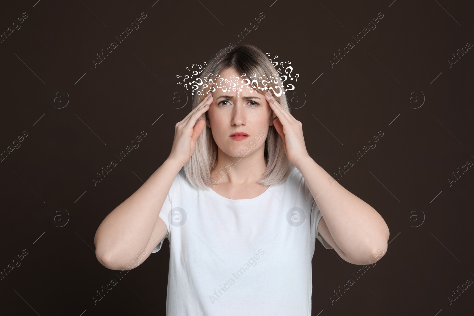 Image of Amnesia concept. Woman trying to remember something on dark background. Wreath of question marks symbolizing memory loss