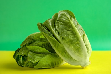 Photo of Fresh ripe cos lettuce on color background