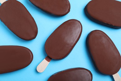 Photo of Glazed ice cream bars in light blue background, flat lay