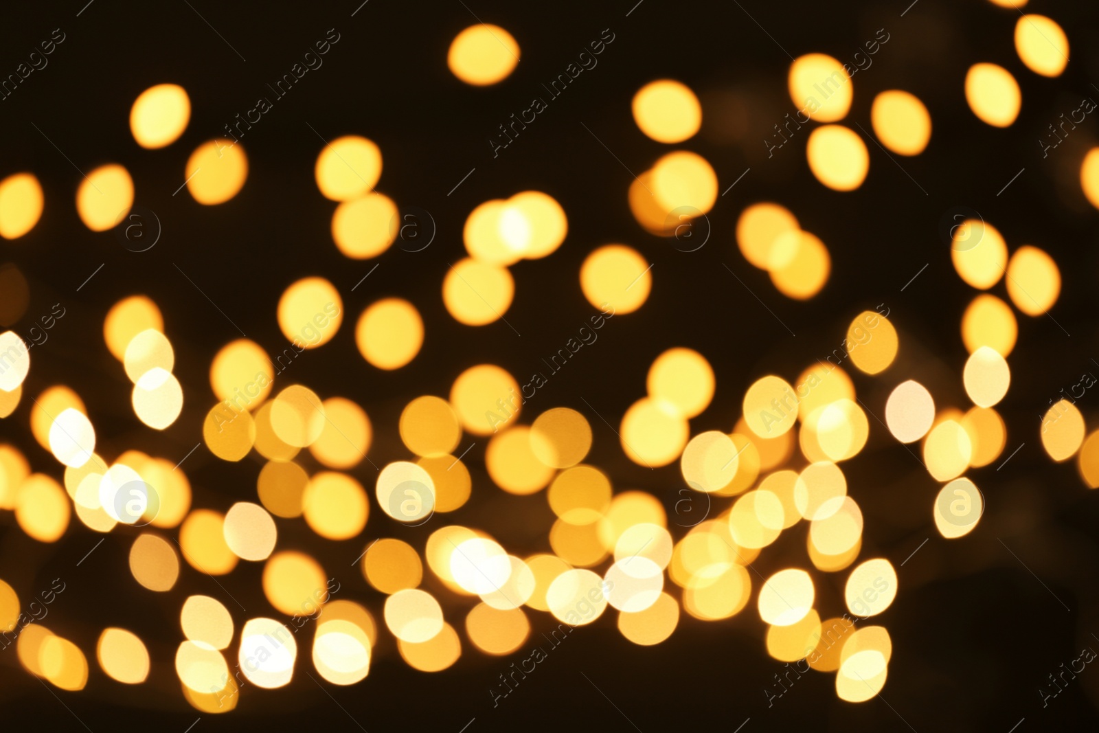 Photo of Beautiful golden lights on dark background. Bokeh effect