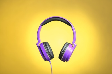 Photo of Stylish headphones with pads on color background