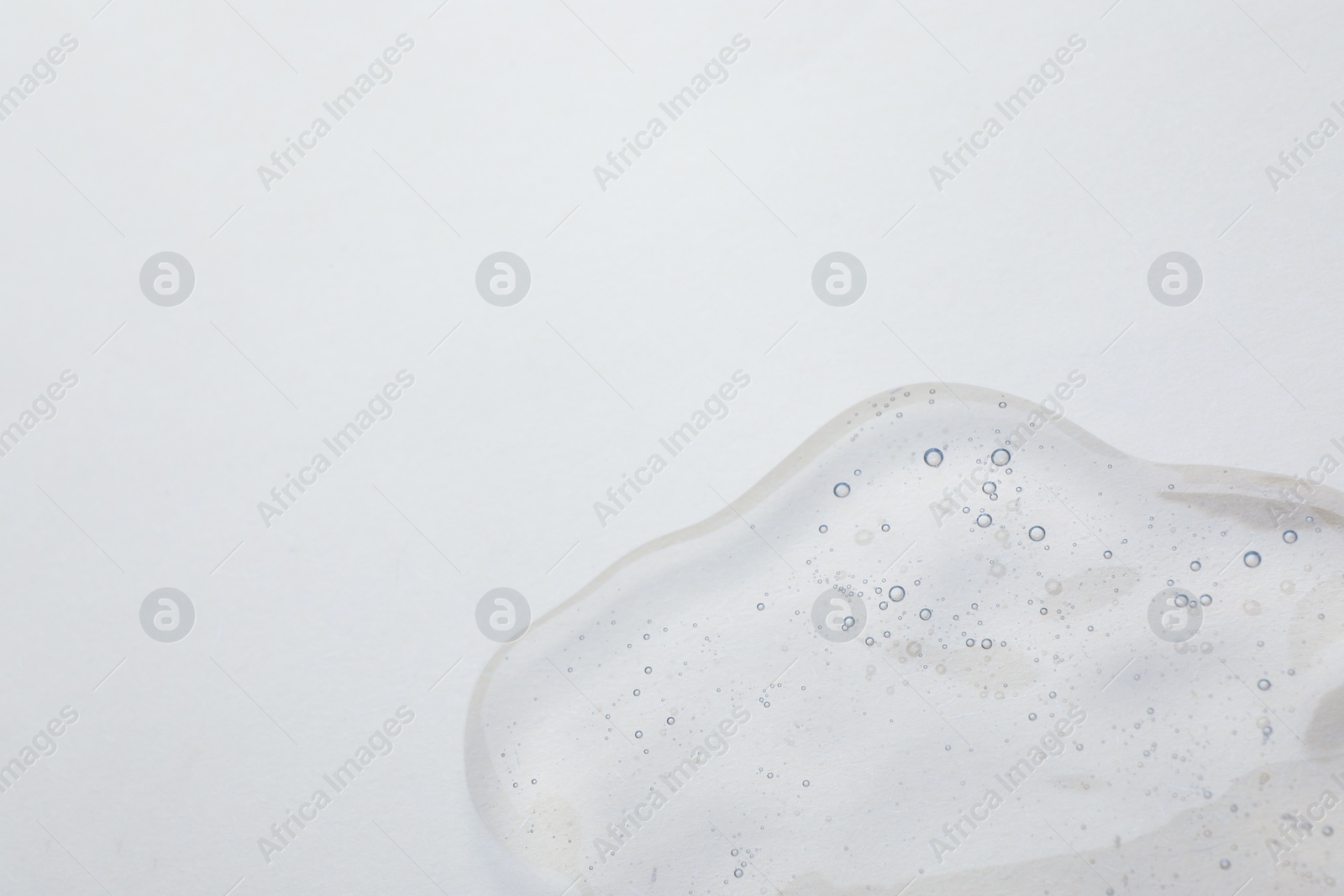 Photo of Sample of cosmetic oil on beige background, closeup. Space for text