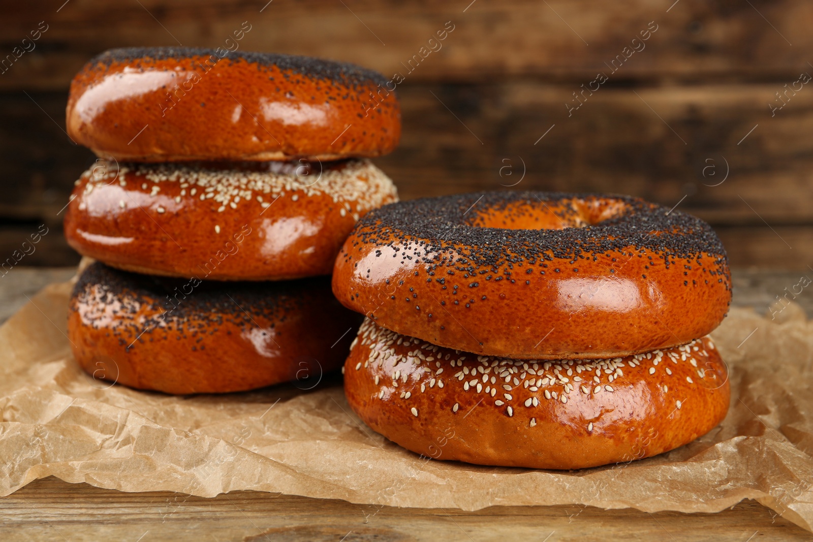 Photo of Many delicious fresh bagels on wooden table