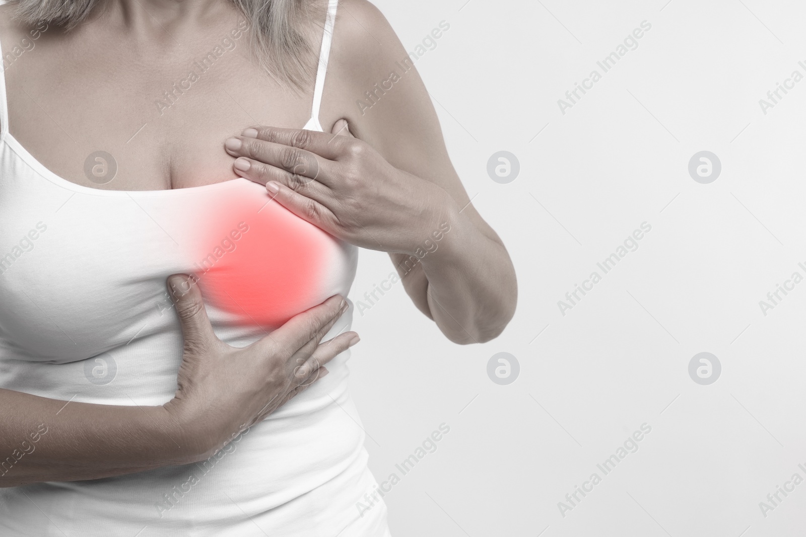 Image of Woman doing breast self-examination on light background, closeup. Color accent effect