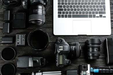 Photo of Flat lay composition with equipment for professional photographer on black wooden table