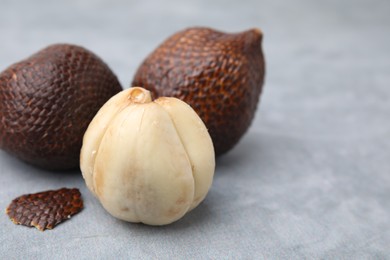 Photo of Fresh salak fruits on light grey table, closeup. Space for text