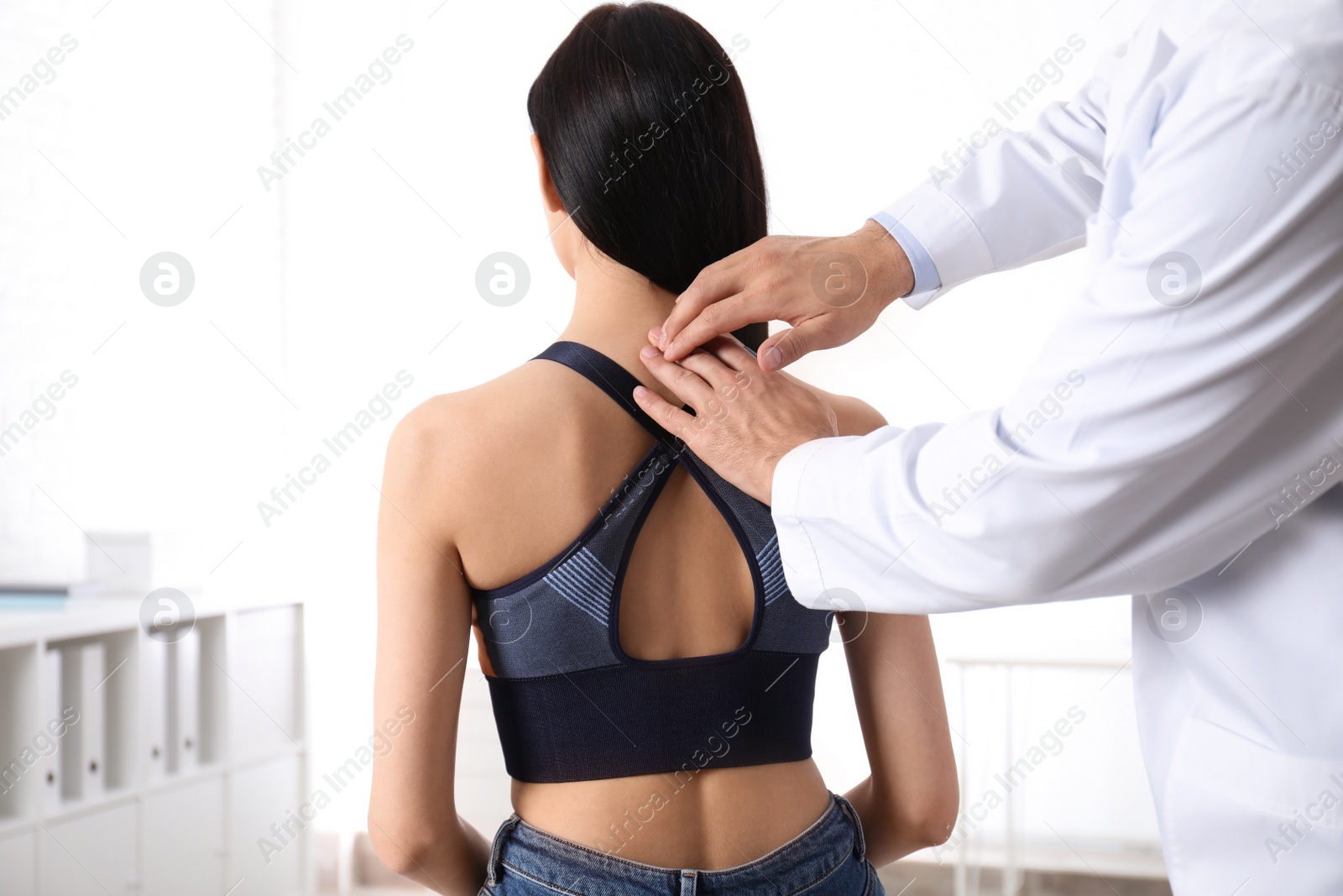 Photo of Professional orthopedist examining woman in medical office