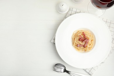 Delicious Carbonara pasta served on white wooden table, flat lay. Space for text