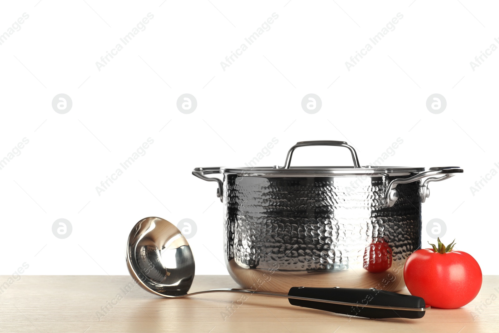 Photo of New clean saucepan, ladle and tomato on table against white background, space for text