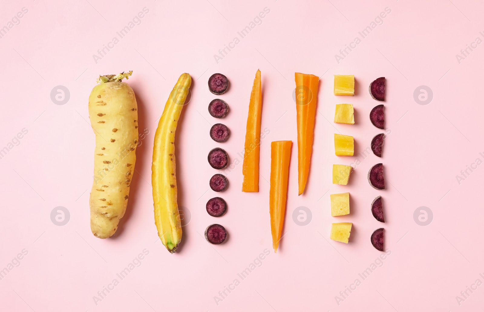 Photo of Whole and cut raw color carrots on pink background, flat lay