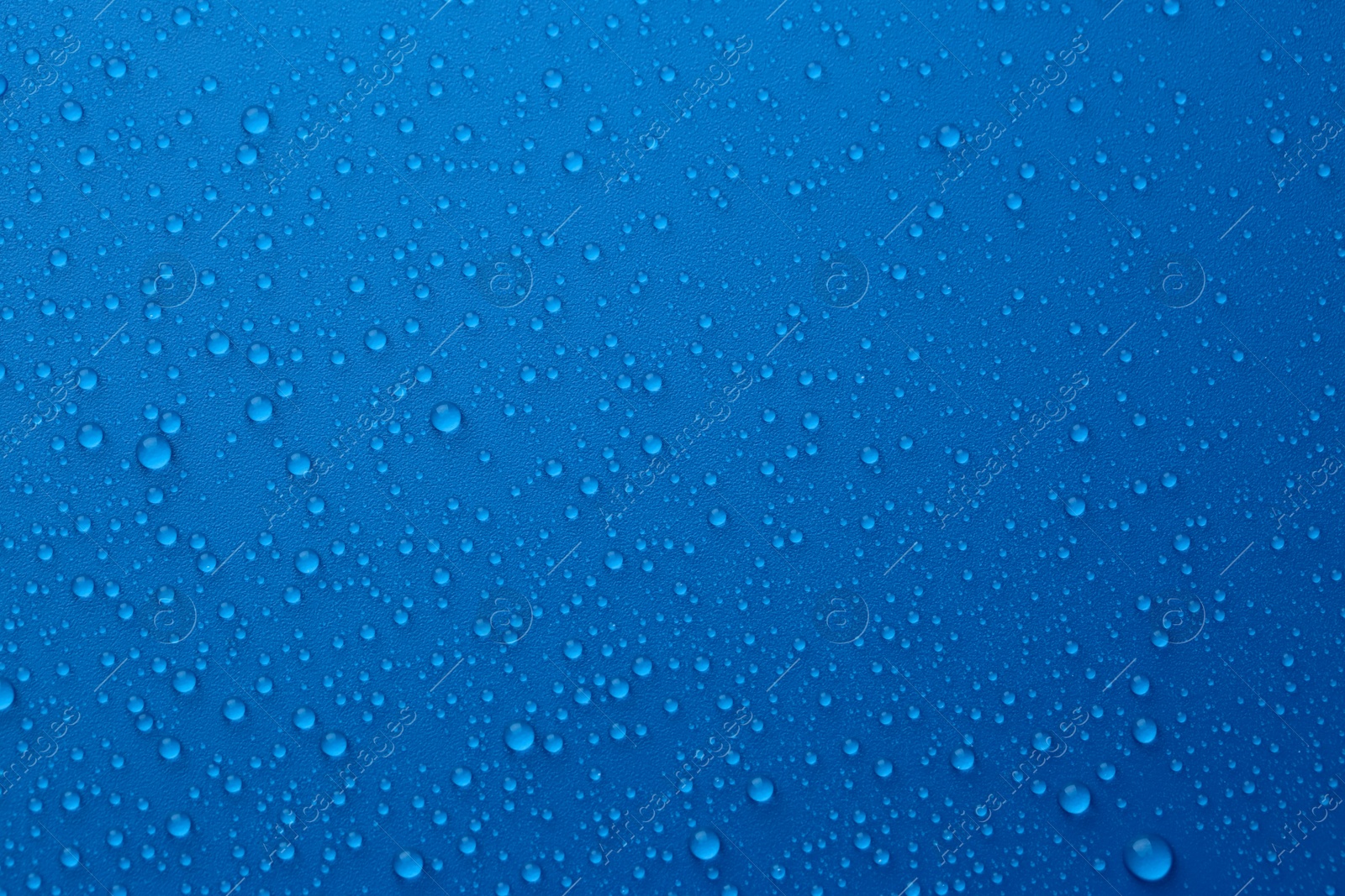 Photo of Water drops on blue background, top view