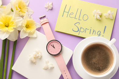 Photo of Flat lay composition with words HELLO SPRING, coffee, wristwatch and fresh flowers on violet background