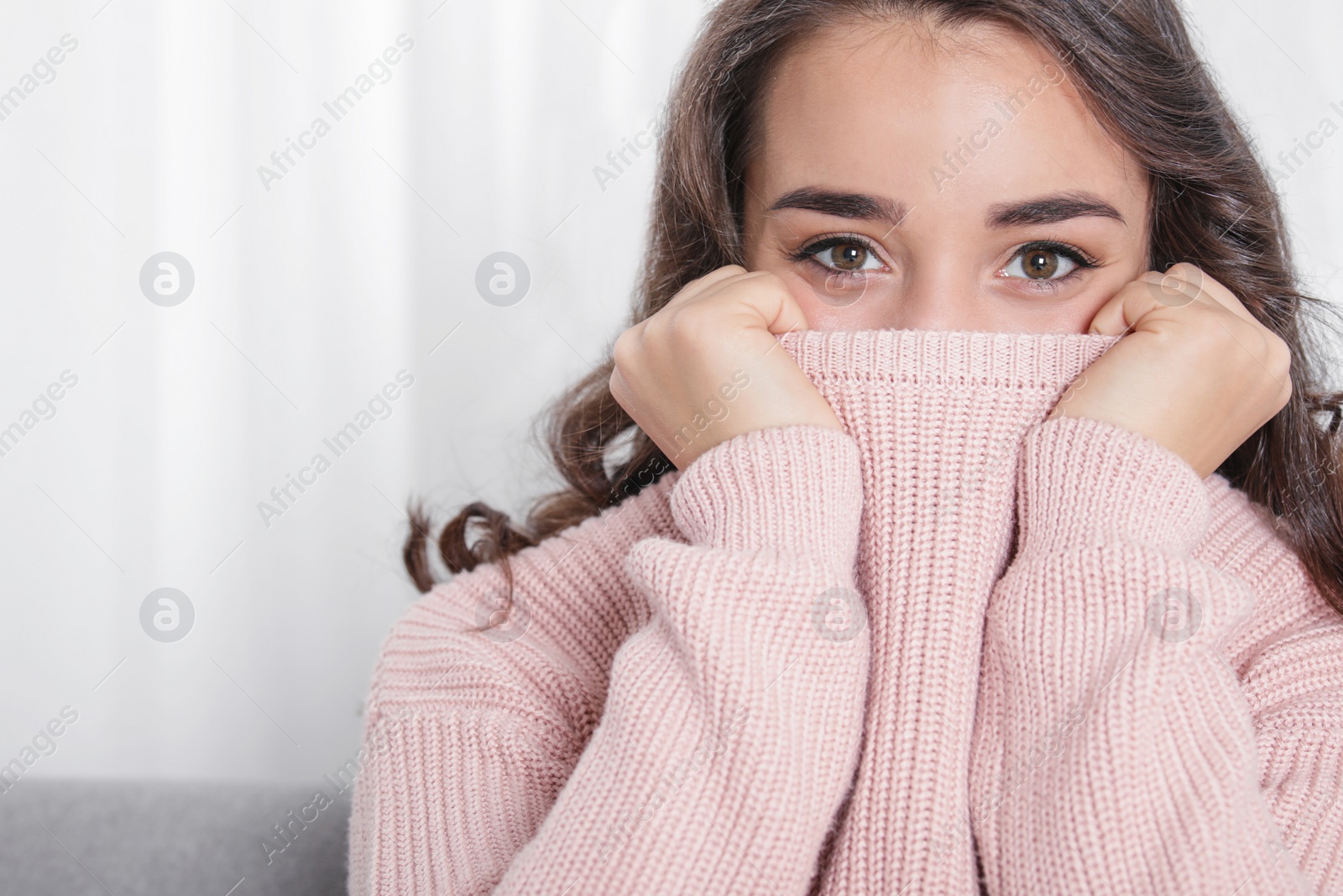 Photo of Young woman in warm sweater at home