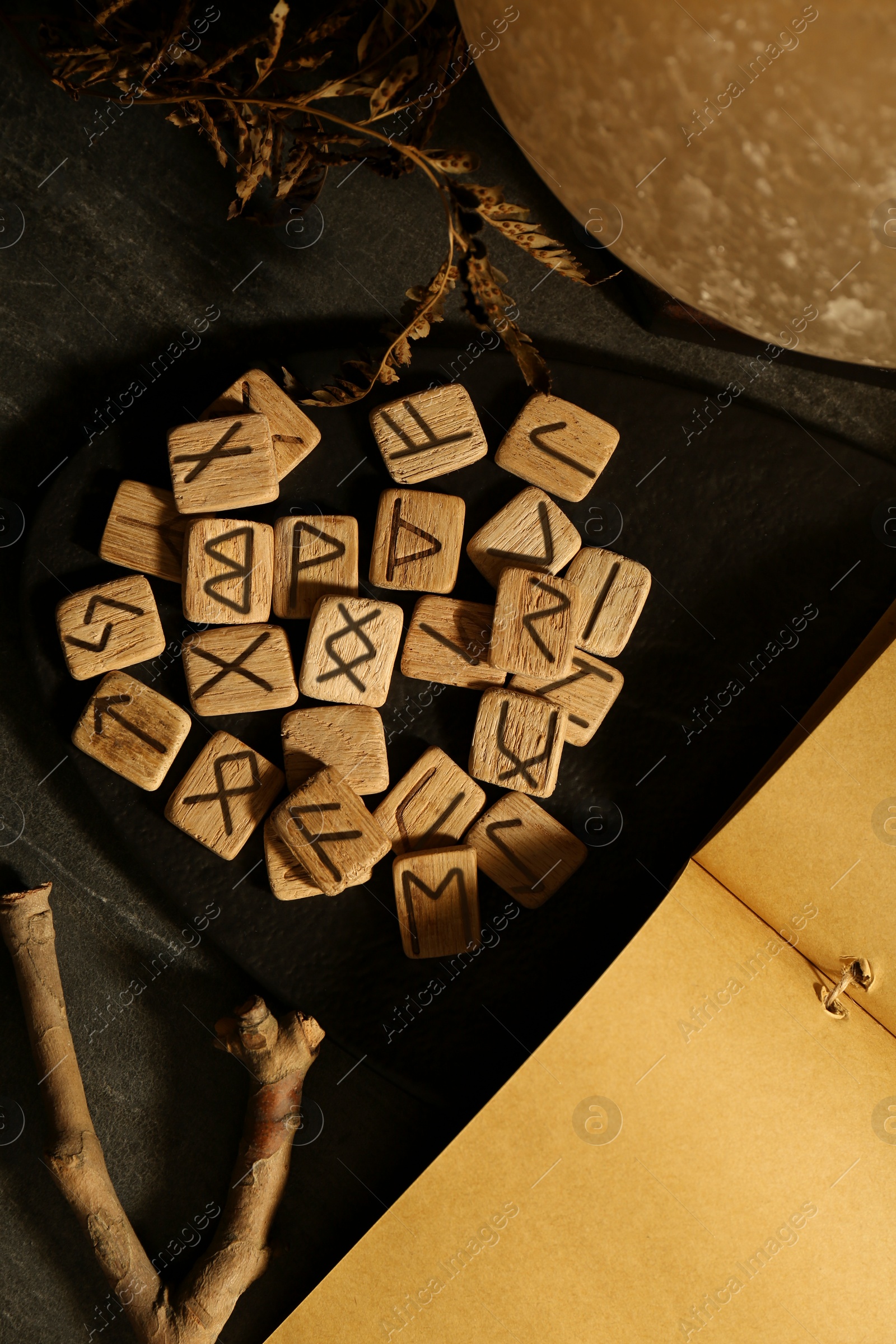 Photo of Composition with wooden runes on black marble table, flat lay