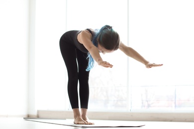 Young woman practicing yoga indoors