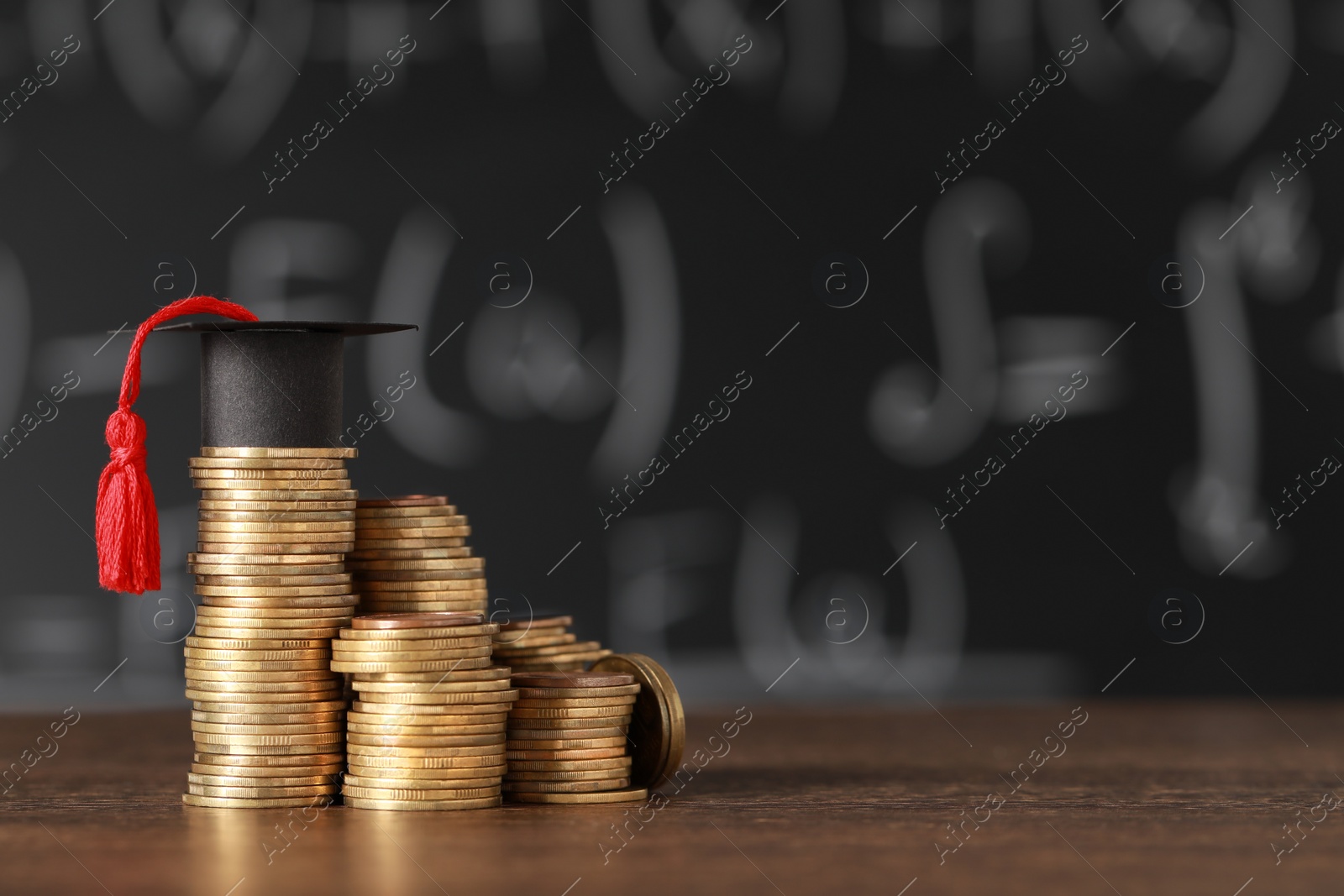 Photo of Scholarship concept. Coins and graduation cap on wooden table, space for text