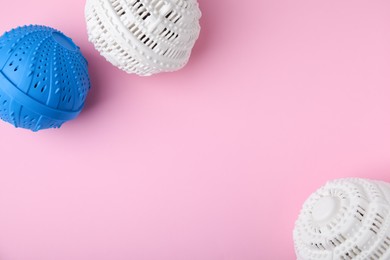 Photo of Laundry dryer balls on pink background, flat lay. Space for text