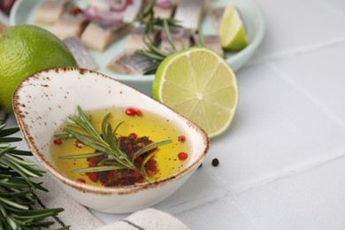 Photo of Tasty fish marinade with rosemary and products on light tiled table, closeup. Space for text