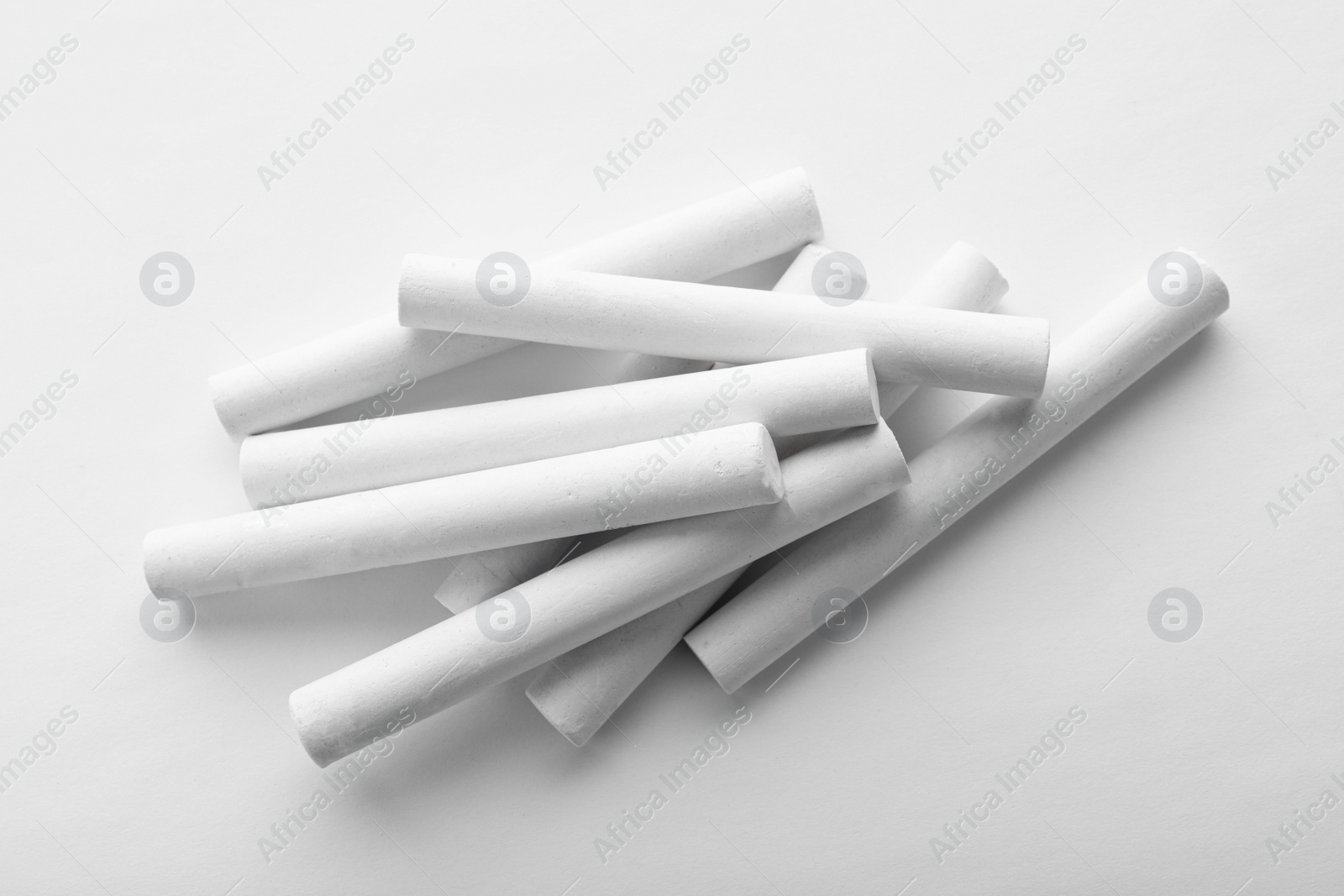 Photo of Pieces of chalk on white background, top view