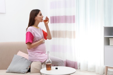 Photo of Future mother drinking alcohol at home. Bad habits during pregnancy