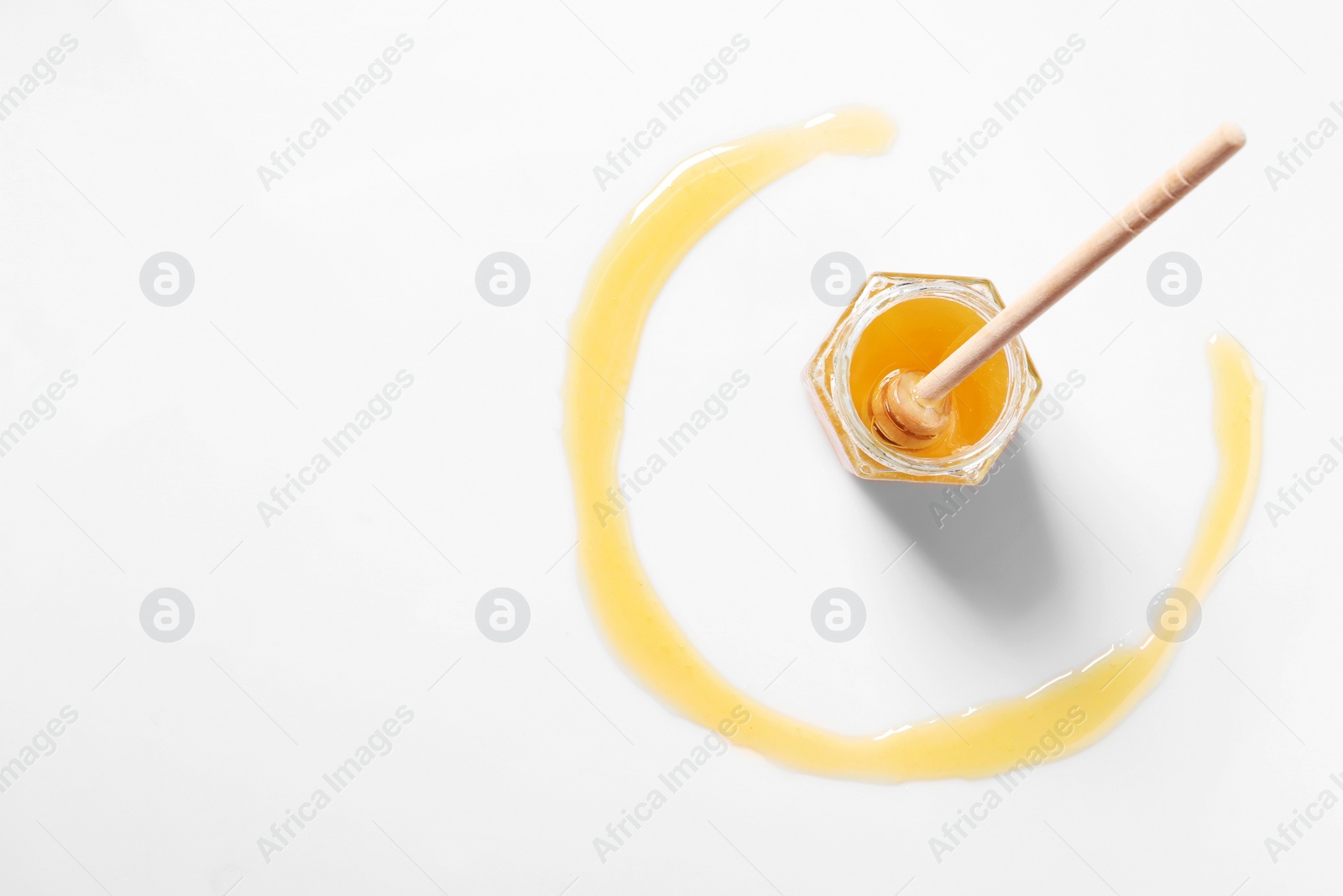 Photo of Jar with tasty natural honey and dipper on white background, top view