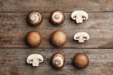 Photo of Flat lay composition with fresh champignon mushrooms on wooden table