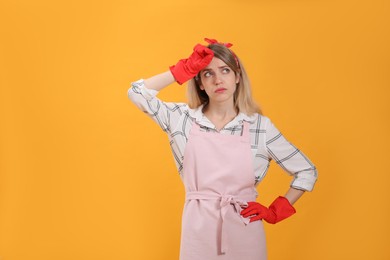 Young housewife in gloves on yellow background. Space for text