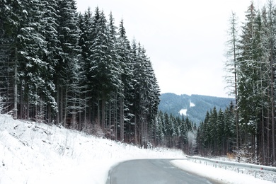 Photo of Beautiful mountain landscape with snowy forest and asphalt road