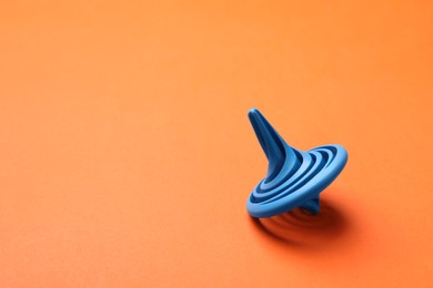 Photo of One blue spinning top on orange background