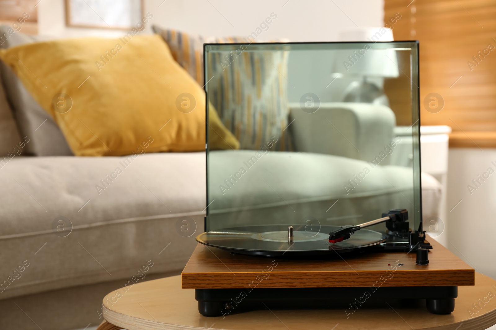 Photo of Modern vinyl record player with disc on table indoors
