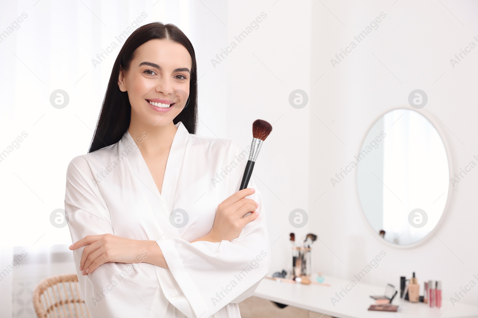 Photo of Beautiful young woman with brush at home. Space for text