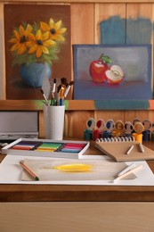 Photo of Artist's workplace with drawing, soft pastels and color pencils on table