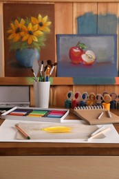 Artist's workplace with drawing, soft pastels and color pencils on table