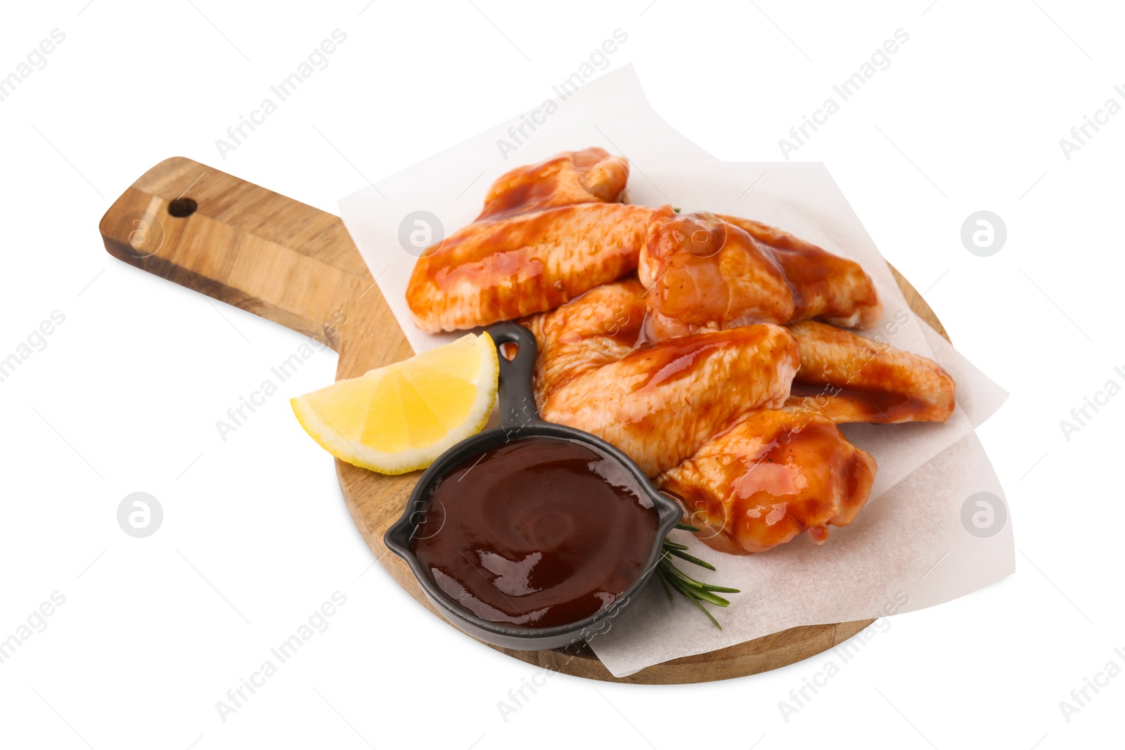 Photo of Board with marinade, raw chicken wings, rosemary and lemon isolated on white