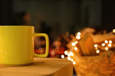 Photo of Yellow cup with hot drink on blurred background, space for text
