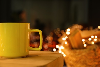 Yellow cup with hot drink on blurred background, space for text