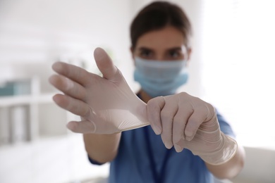Photo of Doctor in medical gloves against blurred background, focus on hands