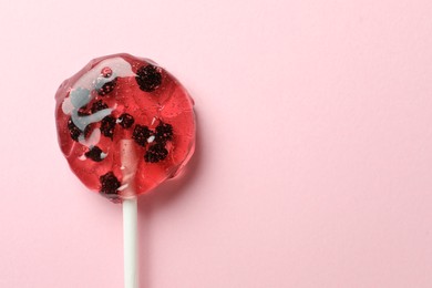 Photo of Sweet colorful lollipop with berries on pink background, top view. Space for text