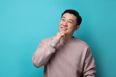 Photo of Portrait of happy man on light blue background. Space for text