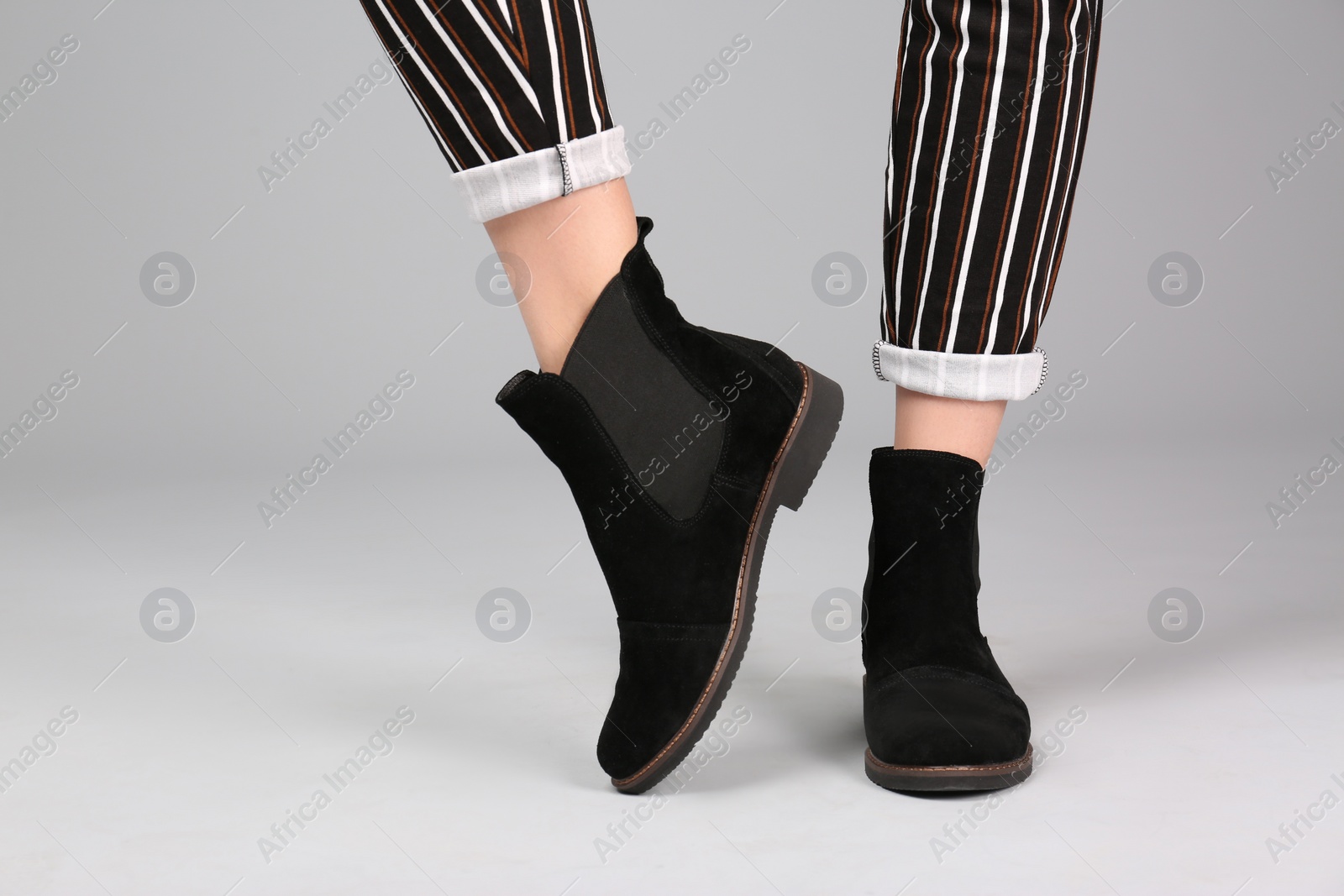 Photo of Woman in stylish shoes on light background