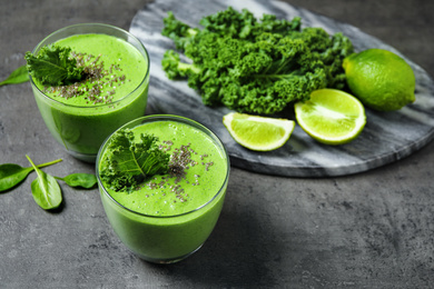 Photo of Tasty kale smoothie with chia seeds on grey table