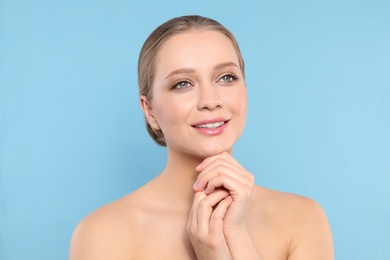 Portrait of young woman with beautiful face on blue background