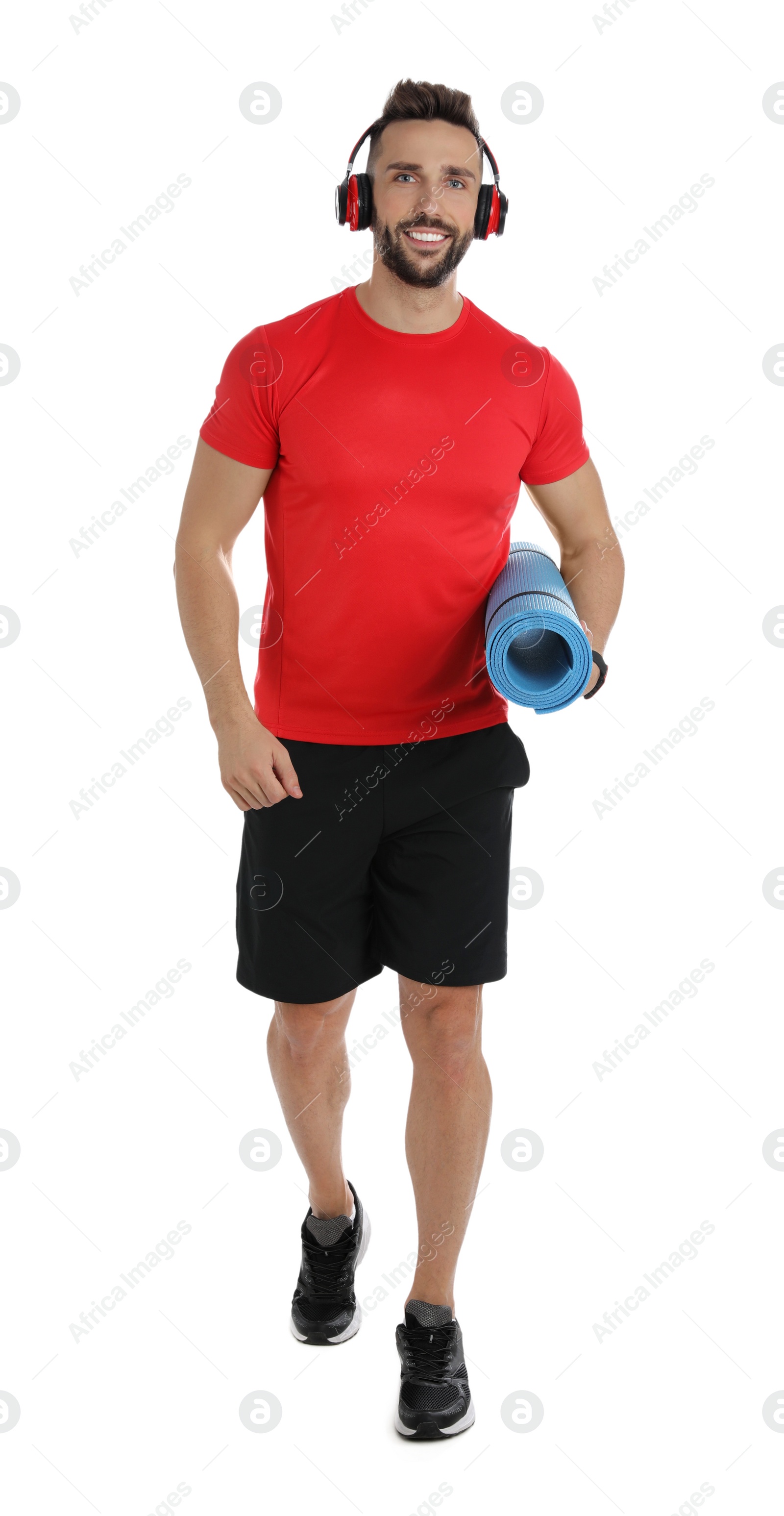 Photo of Handsome man with yoga mat and headphones on white background