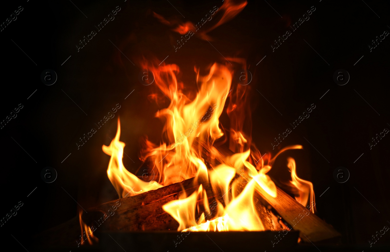 Photo of Fireplace with burning wood, closeup view. Winter vacation