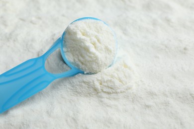 Photo of Powdered infant formula and scoop, closeup with space for text. Baby milk